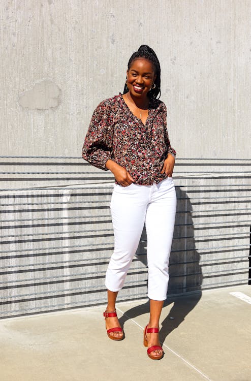 A Woman in White Pants Posing with Her Hands in Her Pockets