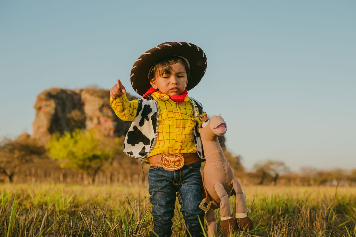 Child in a Woody-style cowboy costume from Toy Story, yellow shirt and cow-print vest