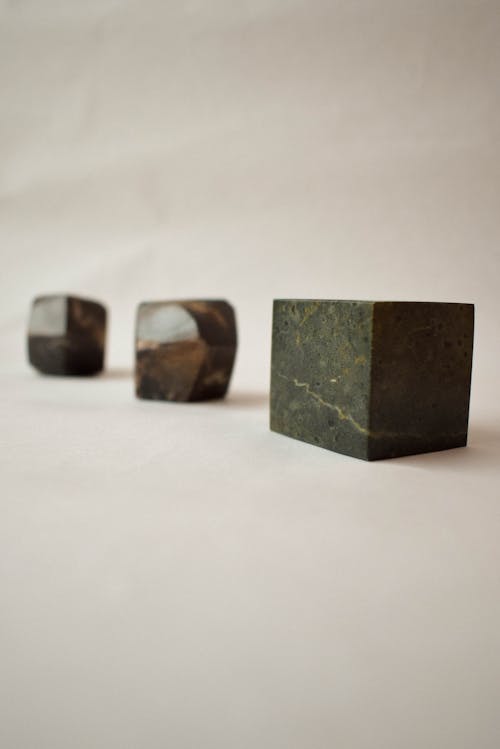 A Cube and Rocks on a White Background