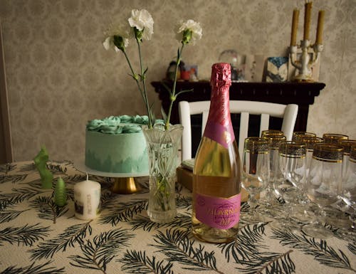 Close-Up Shot of a Bottle of Wine near a Cake