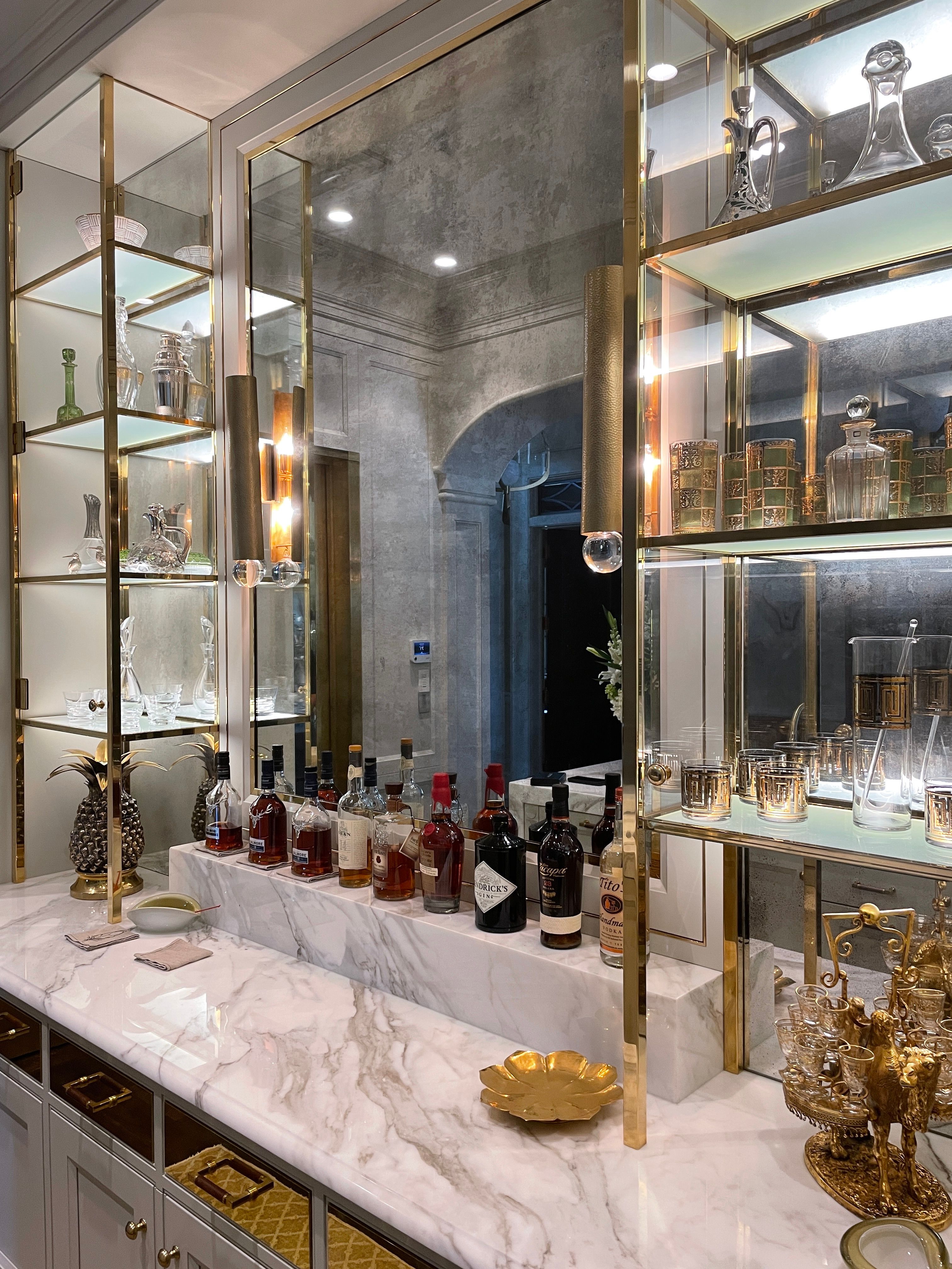 Free Chic home bar setup with marble top and elegant glassware on display shelves. Stock Photo
