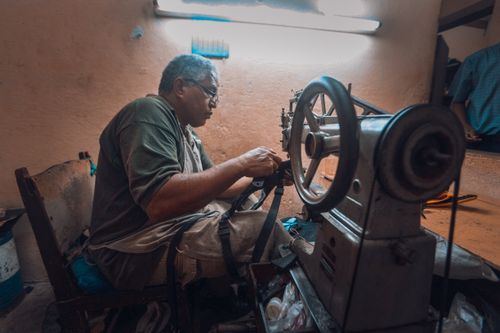 Free Dedicated tailor working meticulously on a sewing machine in a workshop. Stock Photo