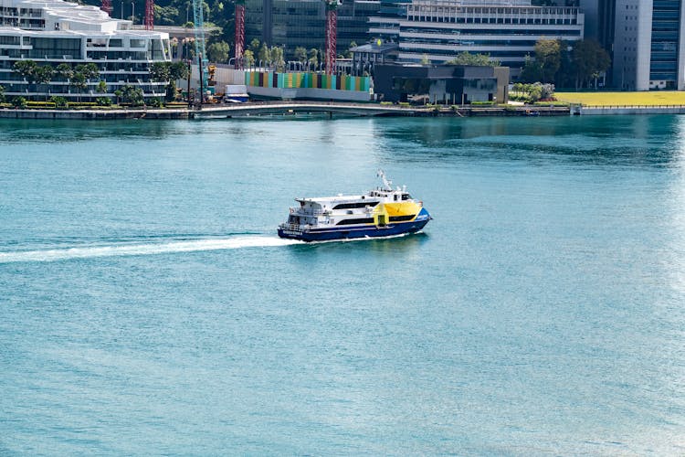 Ferry Boat Traveling On Sea Near City