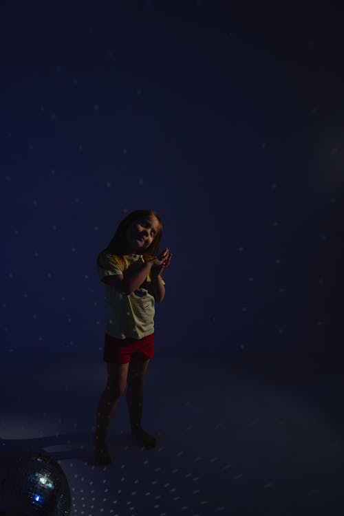 A Girl Standing Near a Mirror Ball