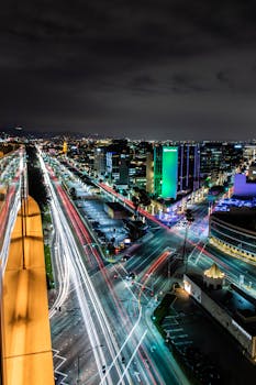 比佛利山庄的夜间城市景观极具戏剧性，展现了充满活力的光路和明亮的建筑