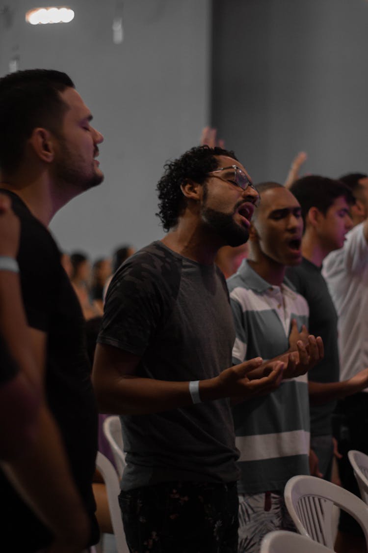 Group Of People Singing  In A Prayer Meeting