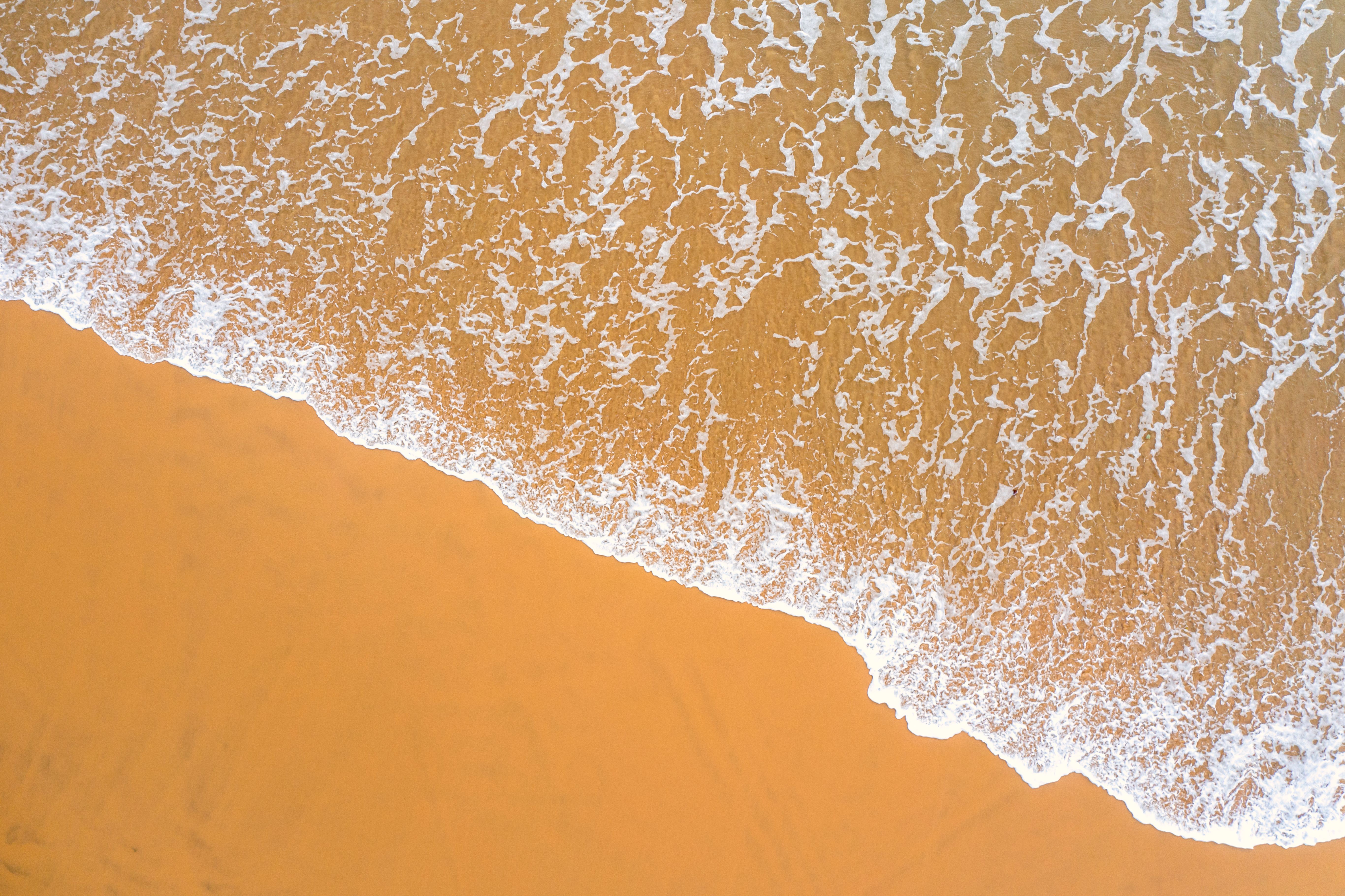 Warm-water reef break with surfers on southern coast