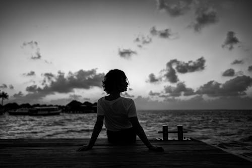 Back View of a Woman Sitting on the Dock