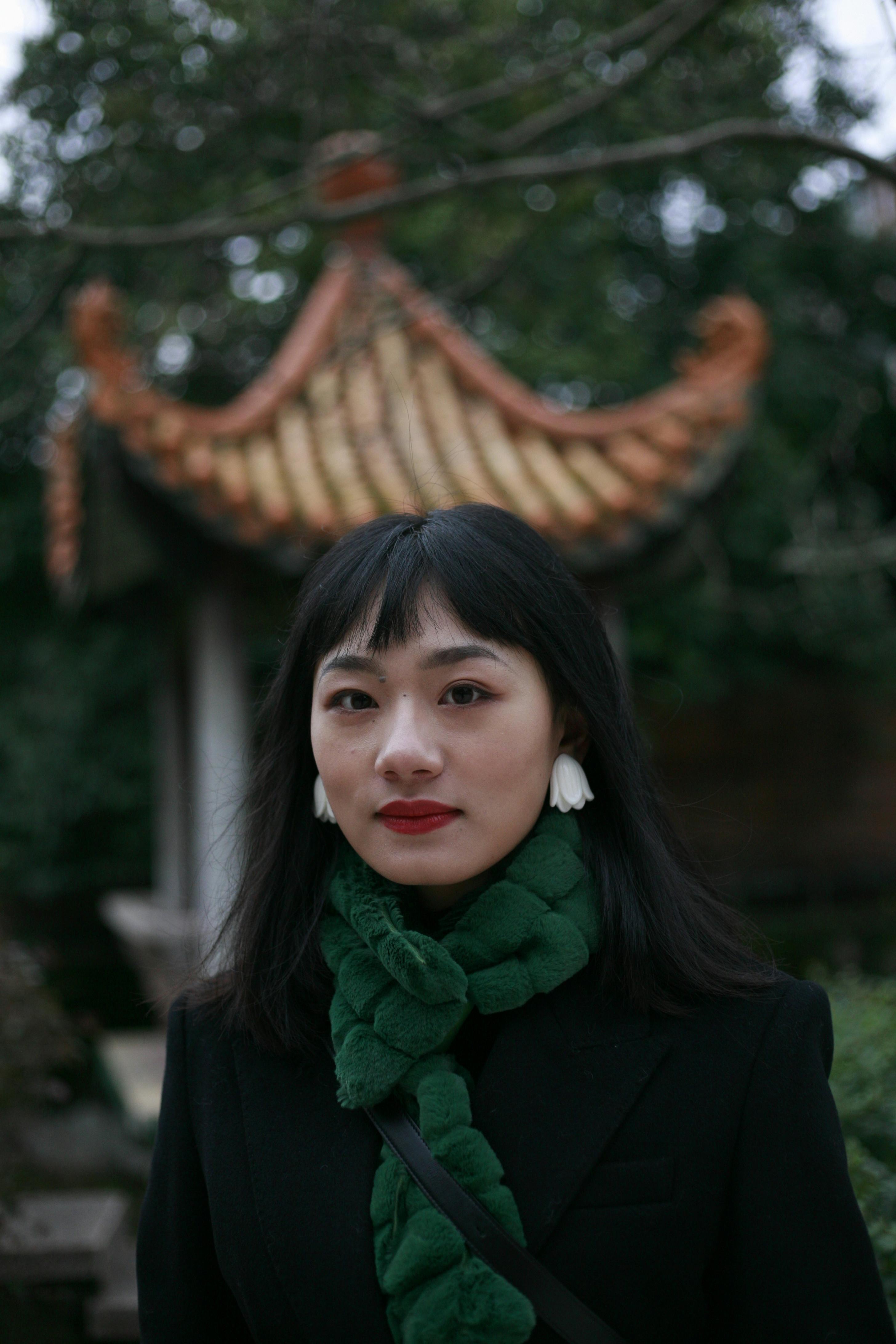 Portrait of an elegant woman with red lips and black hair in a traditional garden.