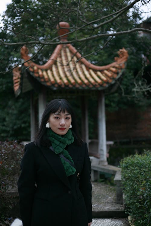 A Woman in Black Coat and Green Scarf