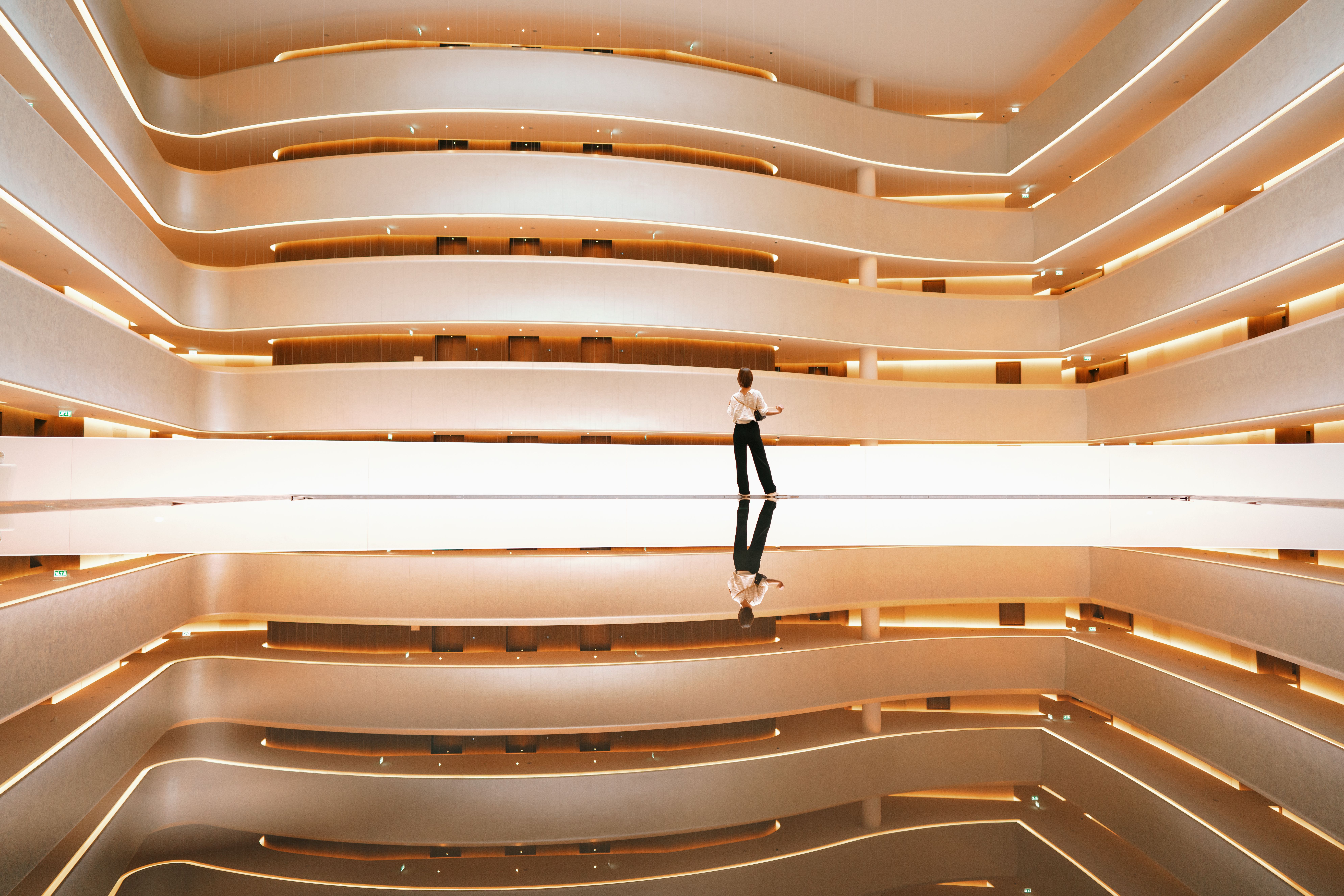 Interior moderno e elegante com design simétrico e superfícies reflexivas, simbolizando a inovação em hotéis.