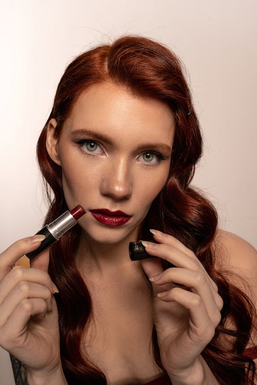 Close-Up Shot of a Beautiful Woman Holding Red Lipstick