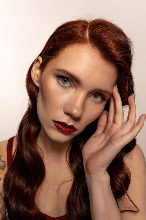 Woman in Red Lipstick while Touching her Head