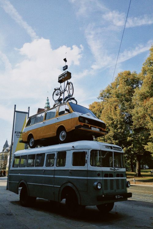 Free Artistic display of a bicycle, van, and bus stacked outdoors during the day. Stock Photo