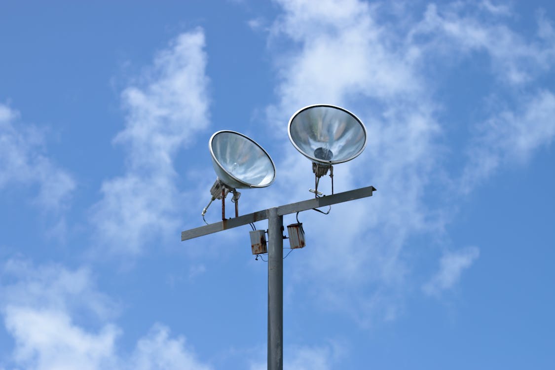 A Pair of Lights on a Steel Pole Under Blue Sky