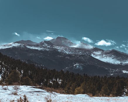 Stunning aerial winter landscape of snowy mountains and forests in Colorado.