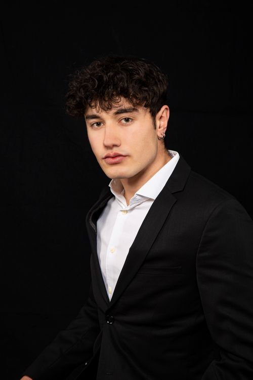 Free Stylish portrait of a man in a black suit with a black background Stock Photo