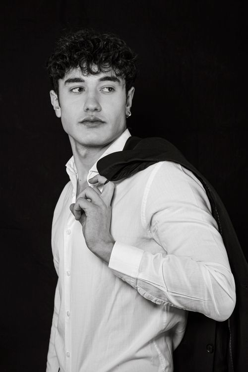 Free Stylish black and white portrait of a young man in formal attire looking to the side. Stock Photo