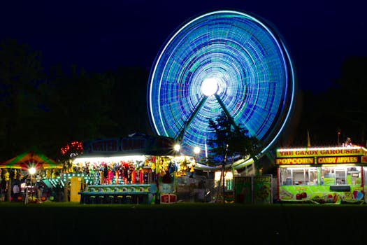 Captivating long exposure of a neon-lit ferris wheel at a busy night carnival.