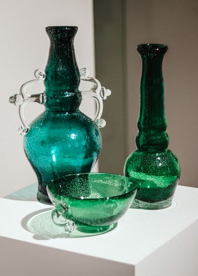 Green blown-glass vessels on a pedestal — photo by Ejov Igor on Pexels