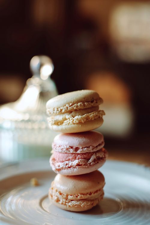 Free Close-up of three stacked macarons on a plate, capturing a sweet and elegant dessert moment. Stock Photo