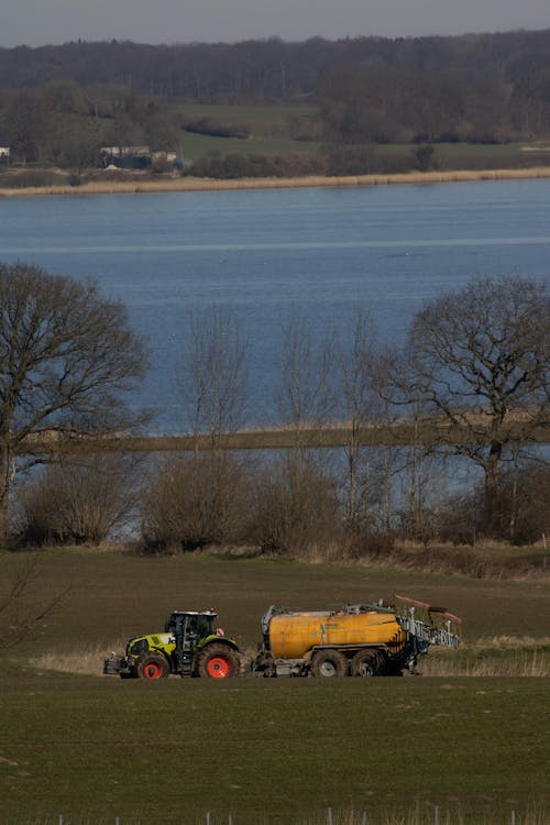 Free Claas tractor on meadow delivering manure and got stuck Stock Photo