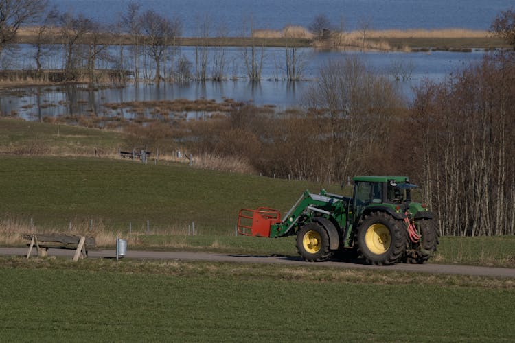 John Deere Tractor With Front Loader Driving Towards Field