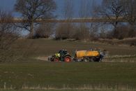 Claas tractor on meadow delivering manure and got stuck