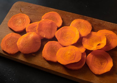 Free Sliced Carrots on a Wooden Chopping Board Stock Photo