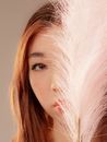 A Woman's Face Partially Covered with White Feathers