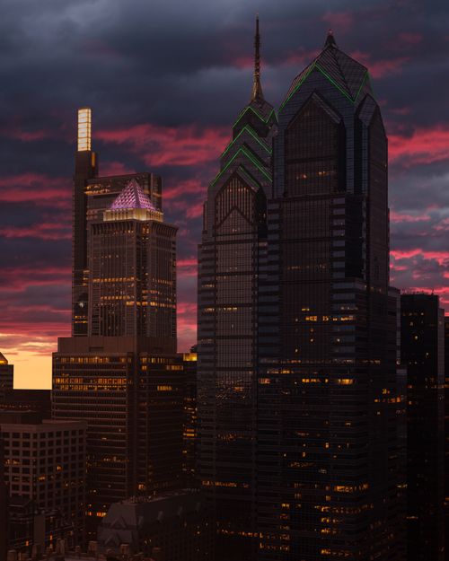 Free View of Philadelphia's iconic skyline against a colorful, dramatic sunset sky. Stock Photo