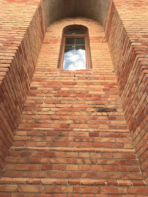 A Glass Window on a Brown Brick Recessed Wall 
