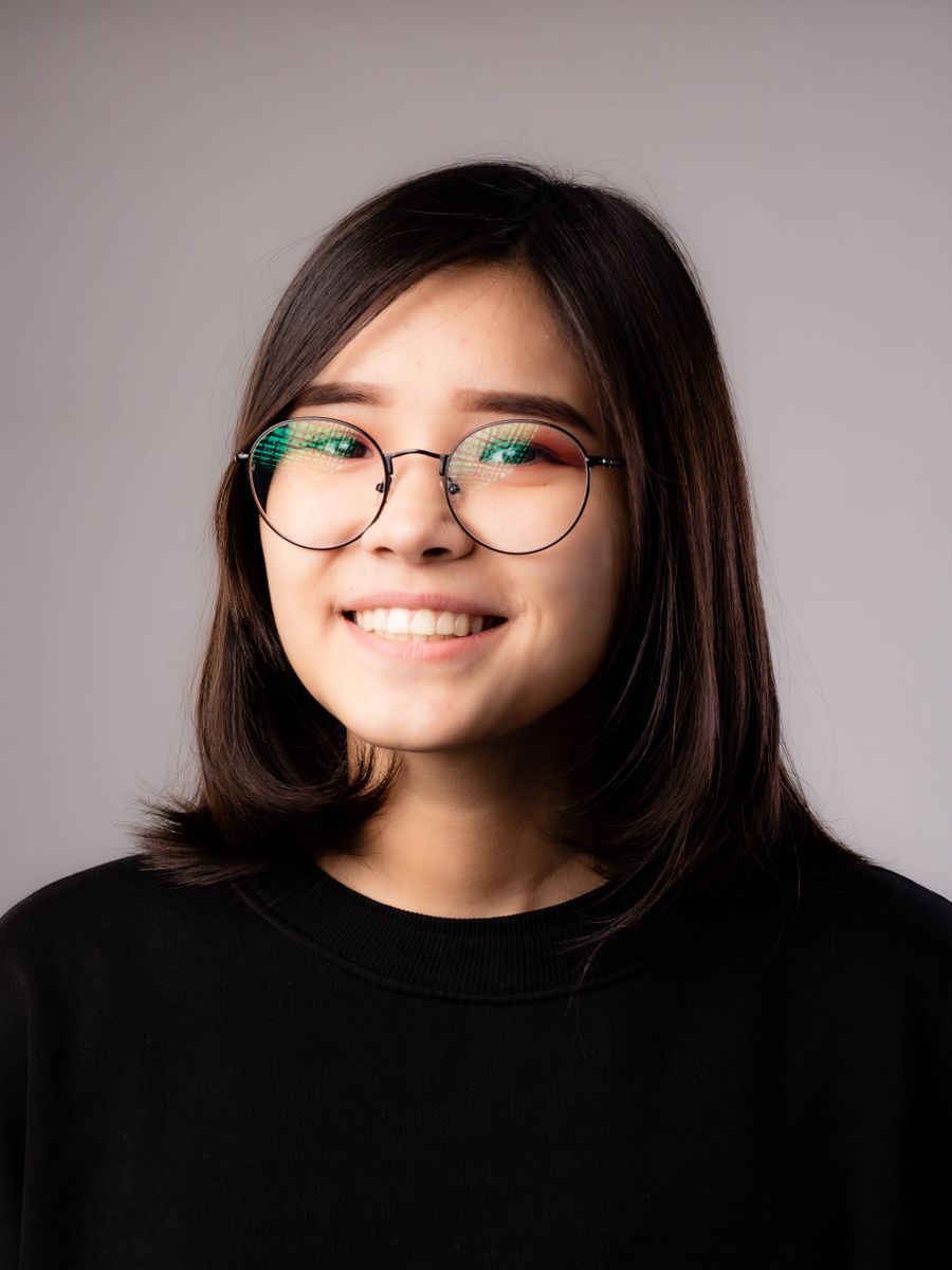 Close-up of a young woman wearing a black tee and glasses