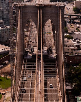 A stunning aerial view of the iconic Brooklyn Bridge in New York City, showcasing its architecture and moving cars.