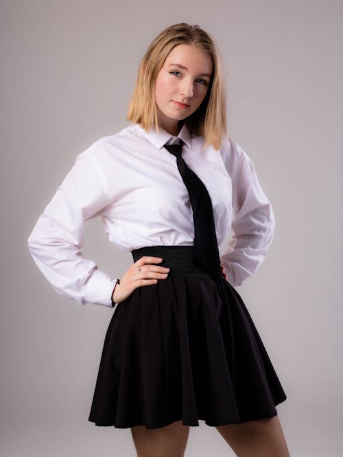 Free A Woman Wearing a White Long Sleeved Shirt and a Skirt Stock Photo