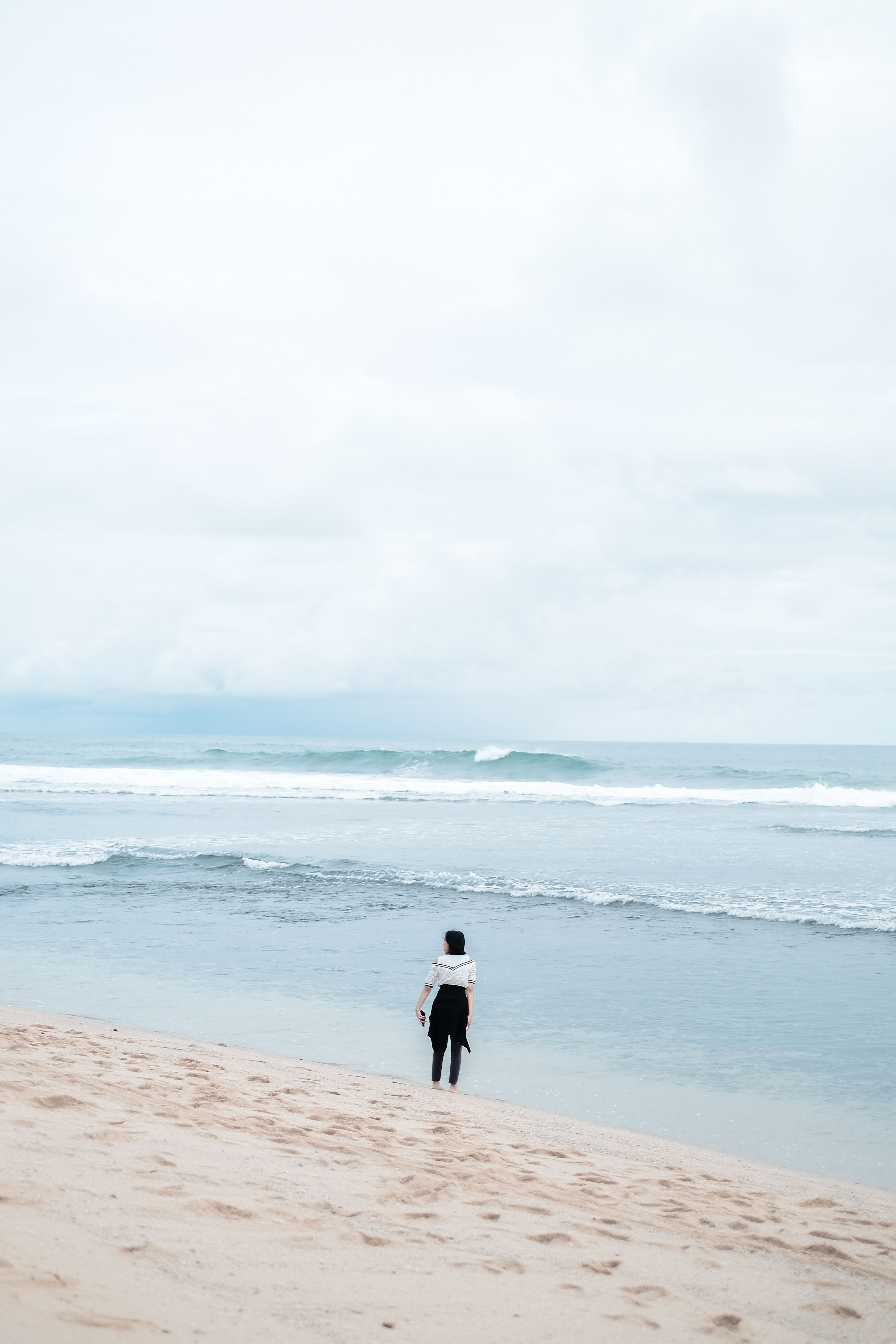Back View of a Woman Standing on a Beach · Free Stock Photo