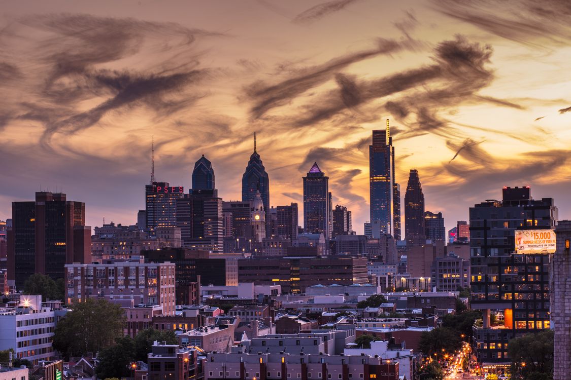 Philadelphia skyline during sunset with dramatic clouds and illuminated buildings