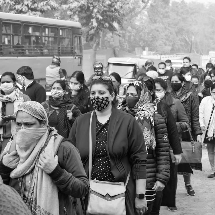 Grayscale Photography Of People Walking On Street Wearing Face Masks