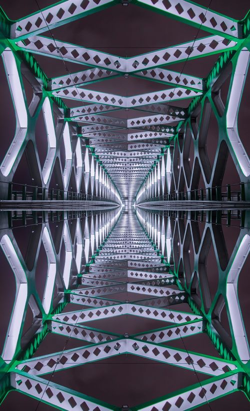 Free Artistic symmetrical photo of an illuminated metal bridge in Bratislava at night, showcasing geometric patterns. Stock Photo