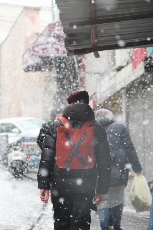 Back View of a Person Carrying a Red Bag while Walking