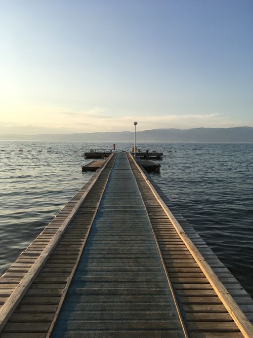 Free Beautiful sunset view from a dock extending into calm waters in Balıkesir, Turkey. Stock Photo