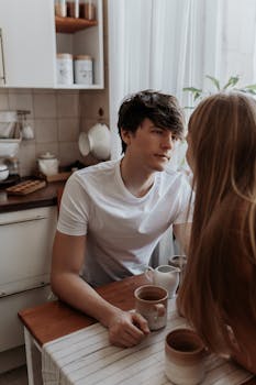 Warm indoor scene of a couple sharing coffee in a cozy kitchen setting.