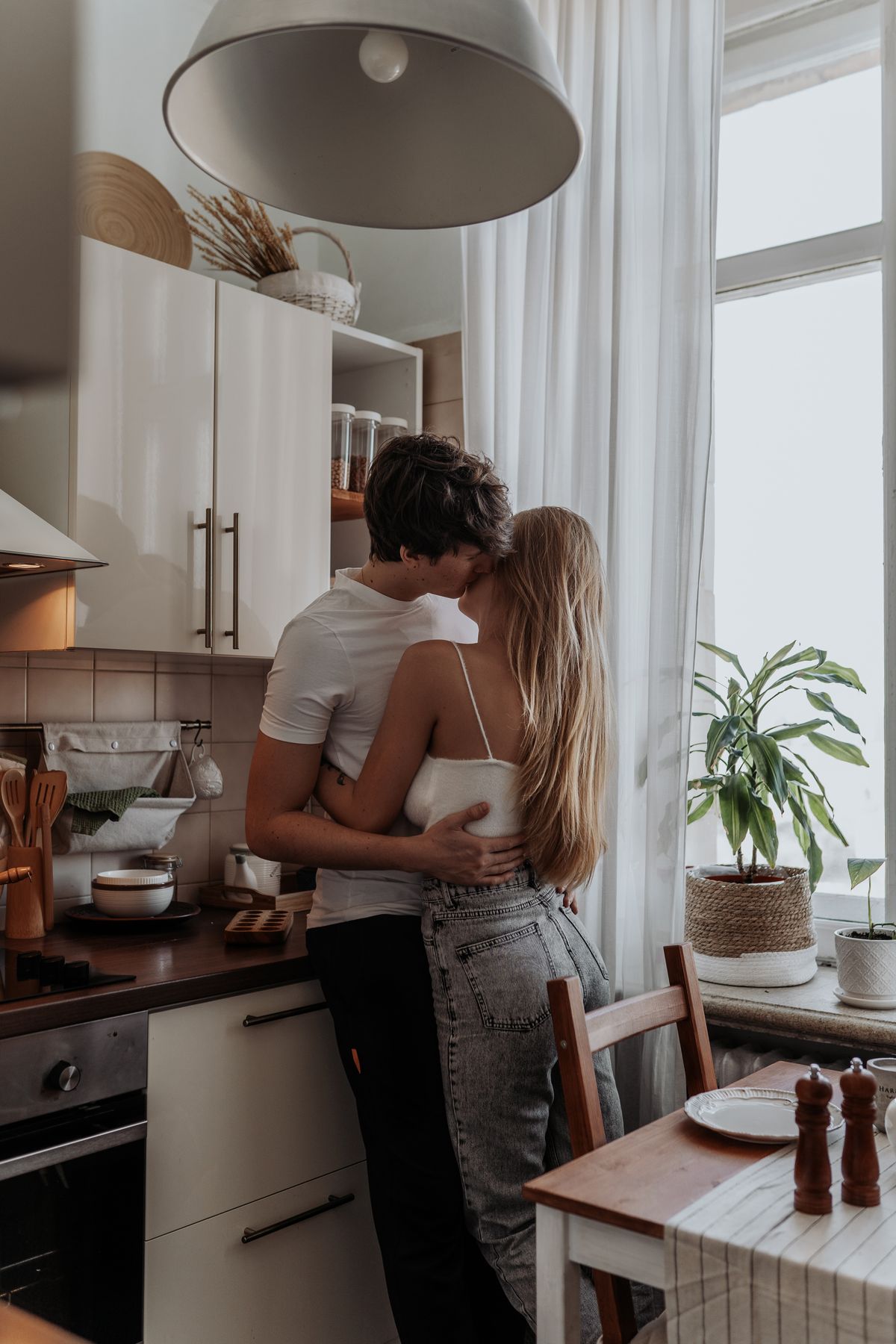 Couple embracing in a softly lit kitchen during a Valentine's slow dance at home