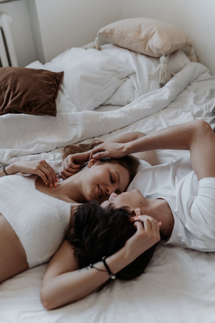 Couple Lying Head To Head In Bed Opposite Each Other 