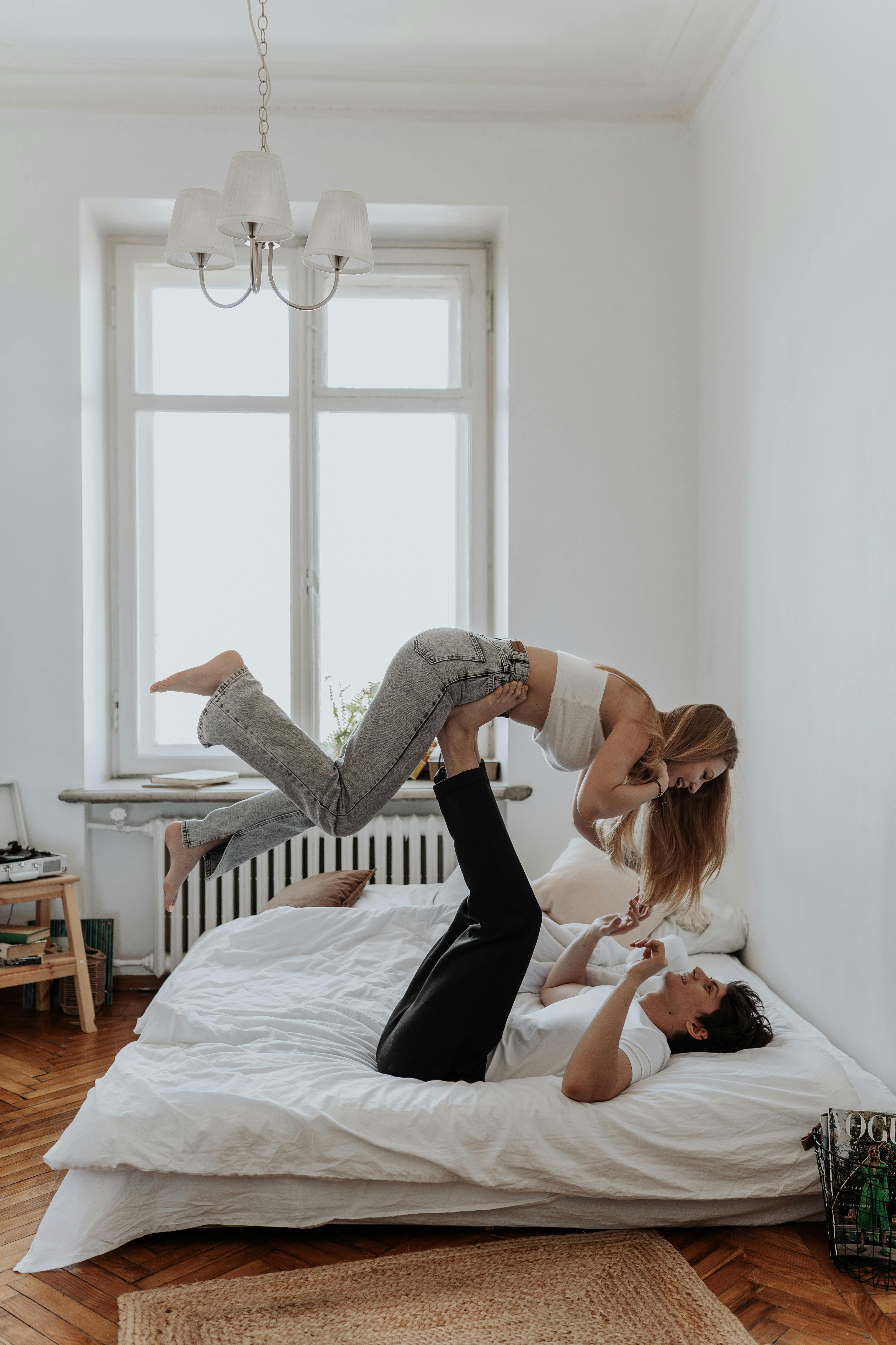 Boyfriend Lifting Girlfriend on His Legs in Bed · Free Stock Photo