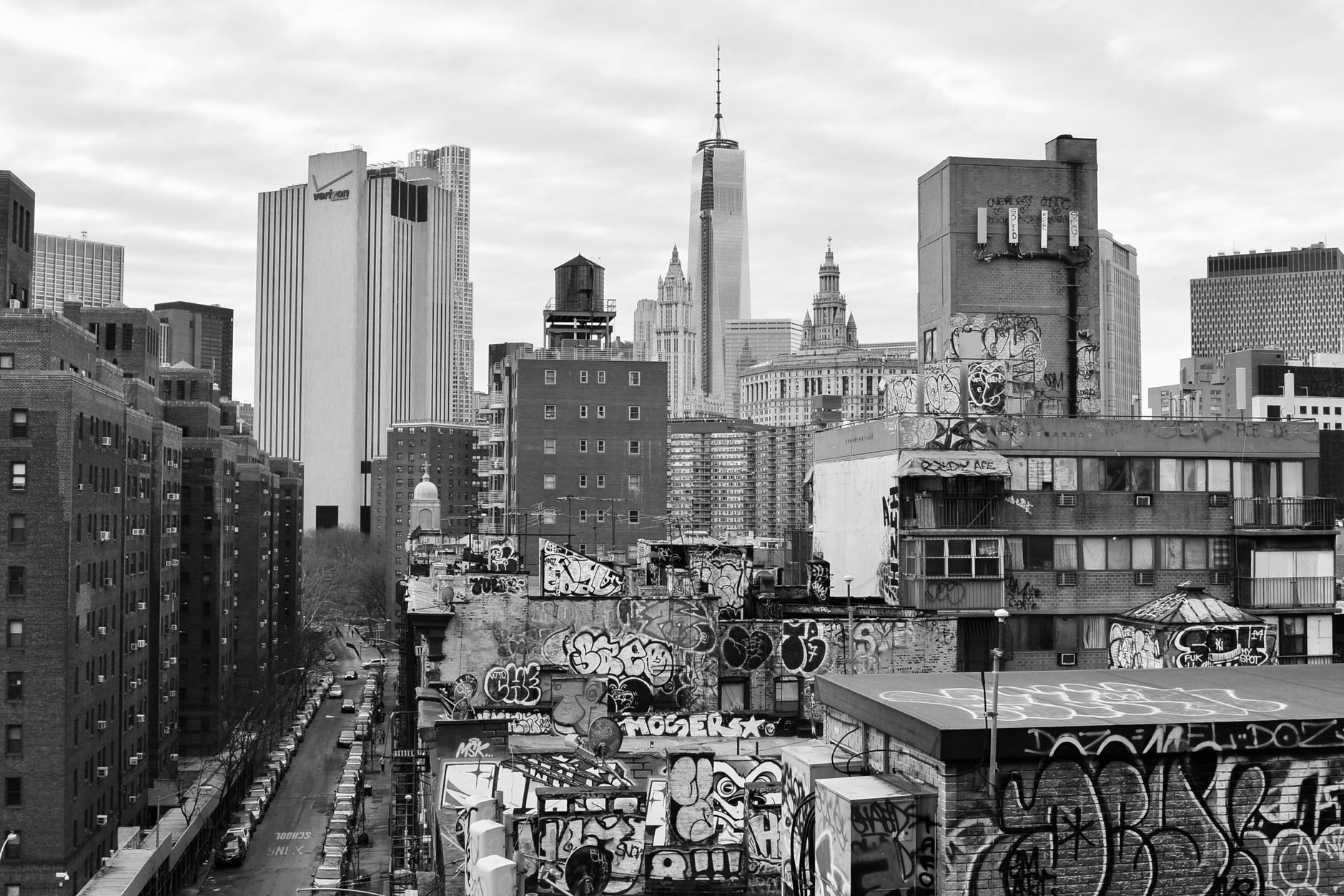 Monochrome view of New York City's skyline featuring skyscrapers and graffiti-covered rooftops.