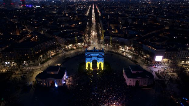 A breathtaking aerial night view of Arco della Pace in Milan, Italy, beautifully illuminated.