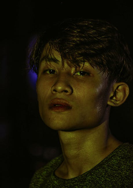 Dramatic portrait of a young man with side profile in a low light setting.