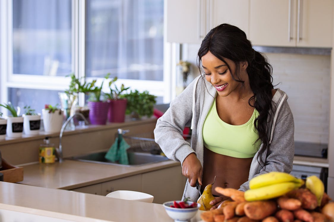 woman in work-out clothes preparing a healthy meal