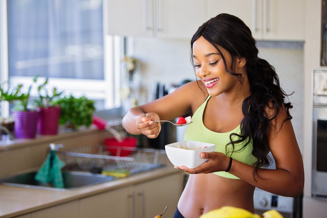 Free Woman Eating Strawberry in the Kitchen Stock Photo